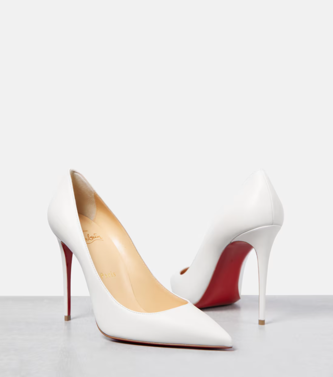 White high-heeled shoes with red soles on a white background