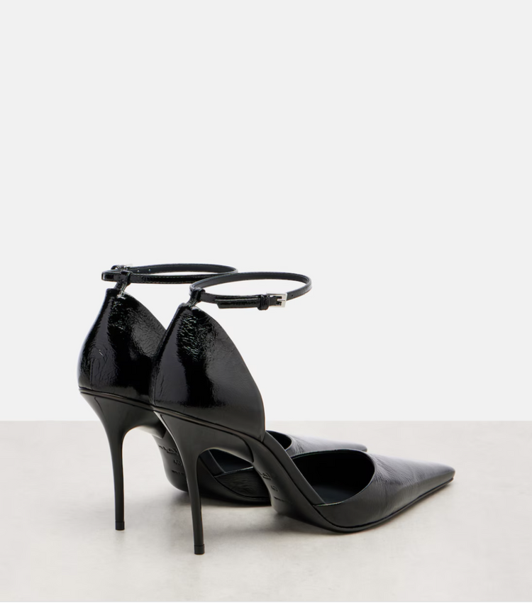 Black high-heeled shoes with ankle strap on a light gray background
