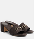Brown Gucci sandals with gold hardware on a white background