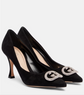 Black high-heeled shoes with decorative GG embellishments on a white background