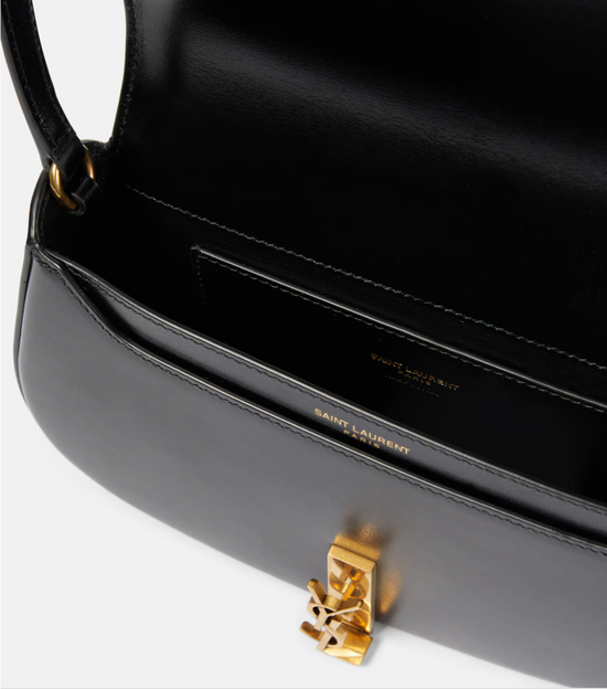 Black handbag with gold clasp on a white background