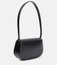 Black handbag with a strap on a light gray background