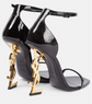 Black high-heeled shoes with gold YSL logo on a white background