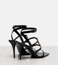 Black high-heeled sandals with strappy design on a light gray background