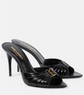 Black high-heeled sandals with gold accents on a white background