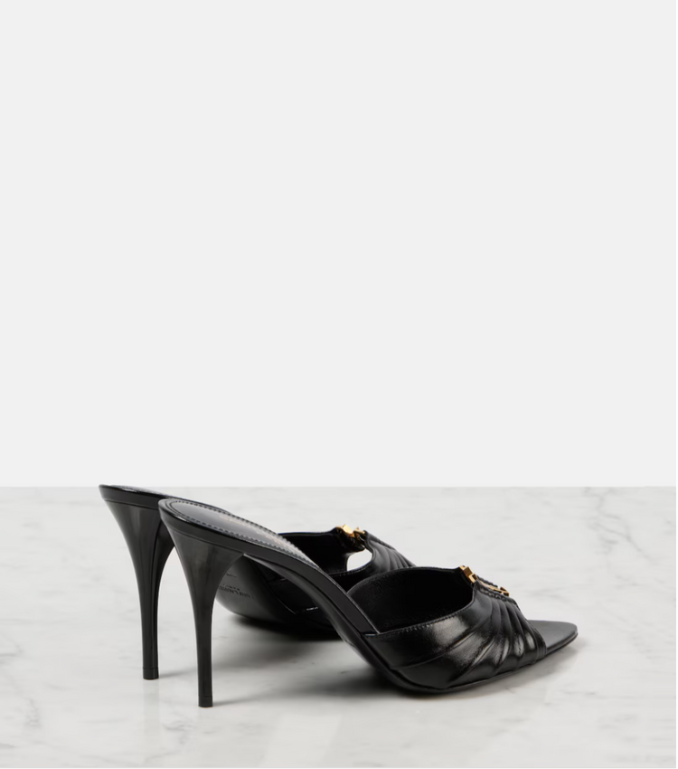 Black high-heeled shoes on a light gray background