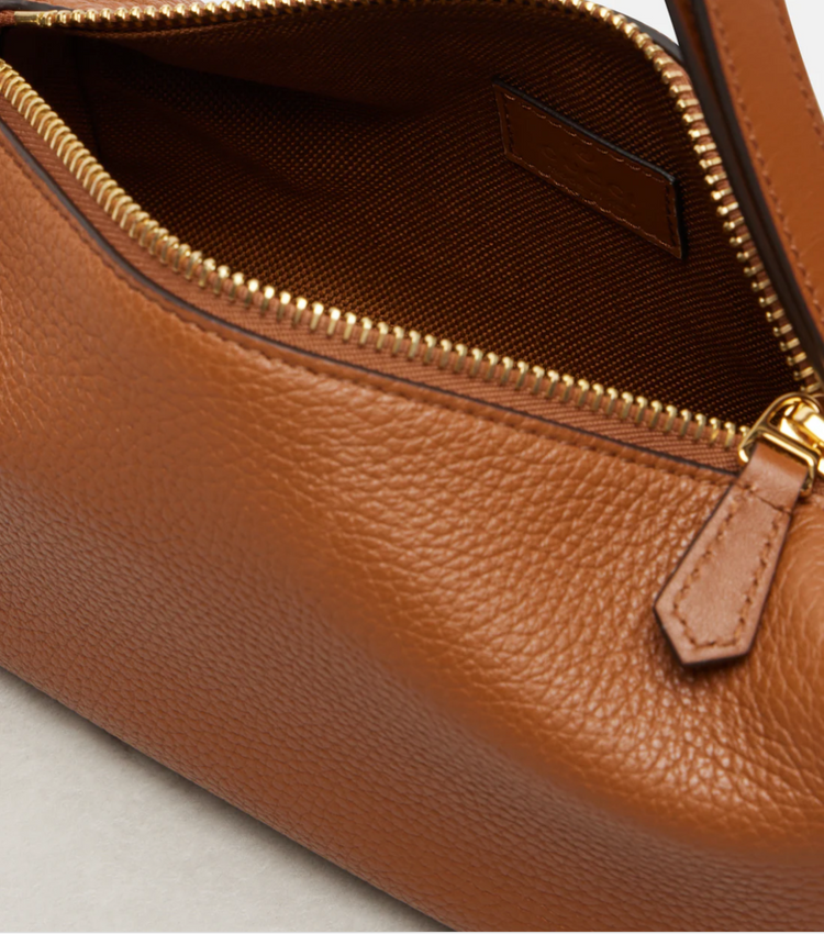 Close-up of a brown leather handbag with a gold zipper.