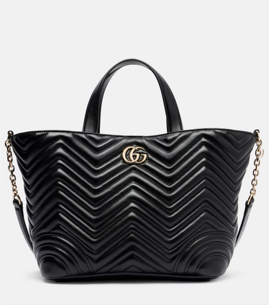 Black quilted handbag with a brand logo on a light gray background