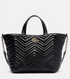 Black quilted handbag with a brand logo on a light gray background