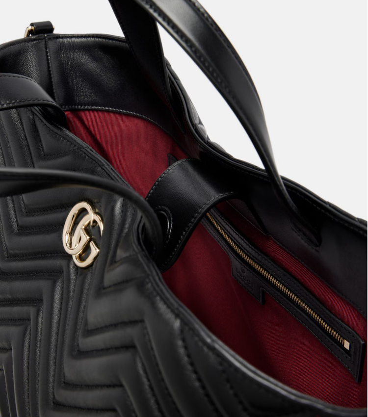 Black handbag with gold logo and red interior