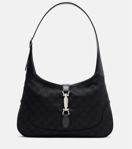 Black handbag with a silver clasp on a light gray background