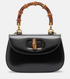 Black handbag with bamboo handle on a white background