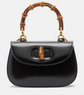 Black handbag with bamboo handle on a white background