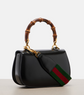Black handbag with bamboo handle and iconic green and red stripe on a light gray background
